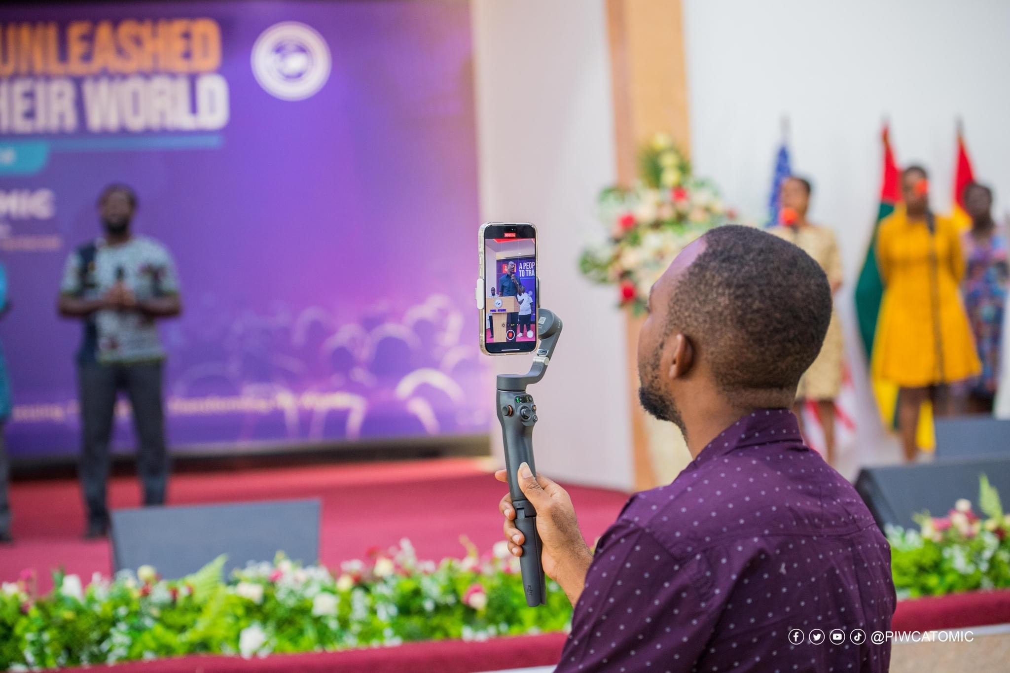 A church media creator recording a live stage session with a mobile phone